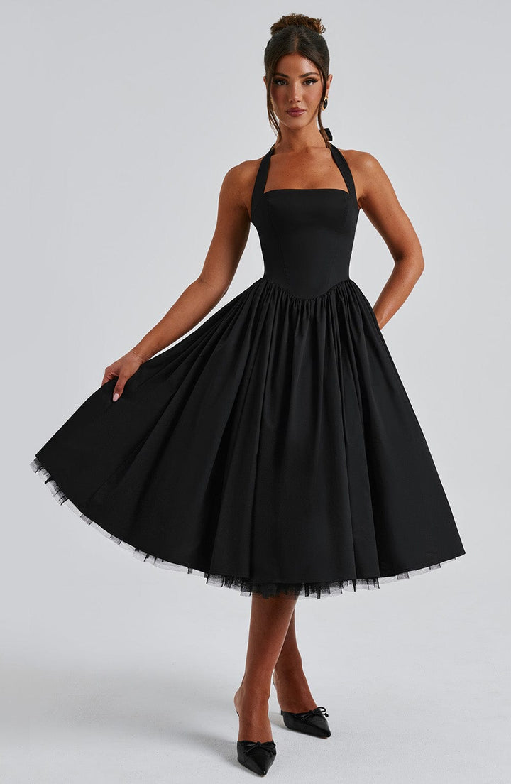 Elegant women's white halter neck midi dress, styled with minimalist jewelry for a formal look