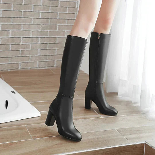 Elegant black knee-high stiletto boots for women, showcasing sleek design and high heel.