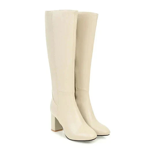 Full view of women's luxurious white heeled knee-high boots, highlighting their elegant appeal.