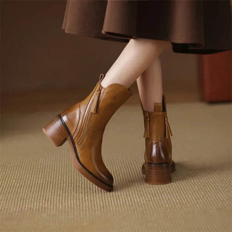 Detail shot of the zipper and block heel on a women's brown ankle boot, emphasizing quality and style.