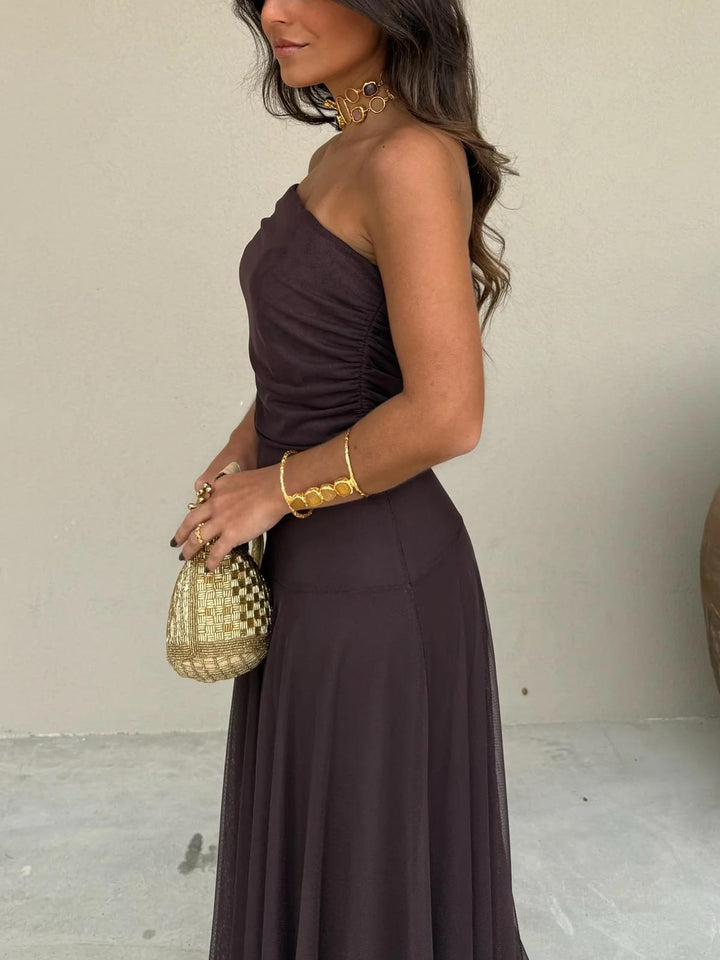 Stylish brown women's maxi dress with off-shoulder neckline & elegant sheer overlay, ideal for weddings.