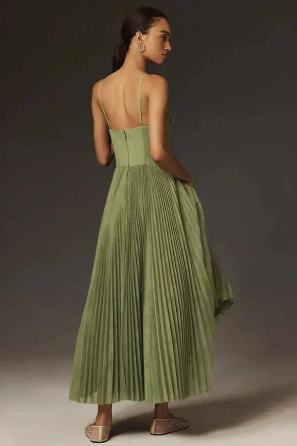 Close-up of a women's elegant green pleated maxi dress, showcasing the strappy neckline