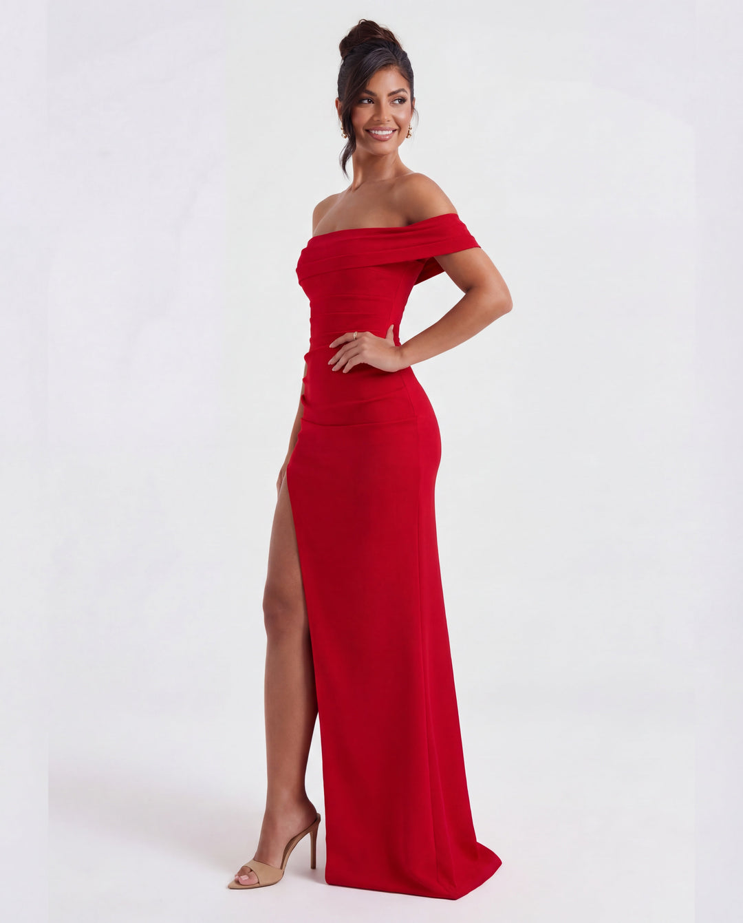 Woman modelling an elegant off-shoulder ruched bodycon maxi evening gown for a special occasion.