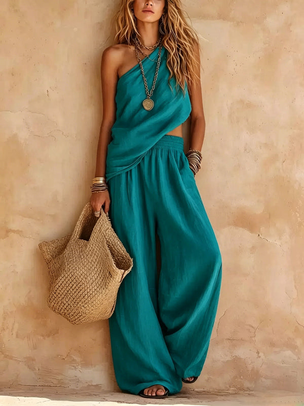 Chic one-shoulder wide-leg jumpsuit. Elegant women's resort wear or party outfit with a flowing drape.
