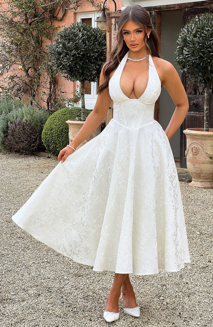 Back view of a women's pink halter neck midi dress, showcasing its elegant design.