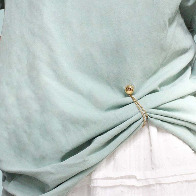 Versatile magnetic clips for clothing, shown holding a scarf in place and cinching a cardigan.