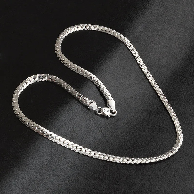 Close-up of a silver-tone lucky charm pendant necklace. Elegant women's jewelry, a versatile statement piece.