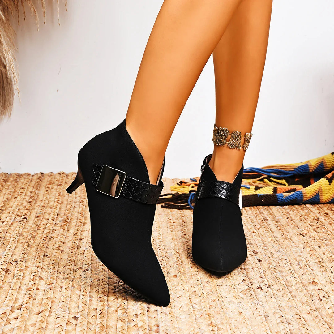 A pair of black pointed toe stilettos, highlighting their slender heel and elegant silhouette.