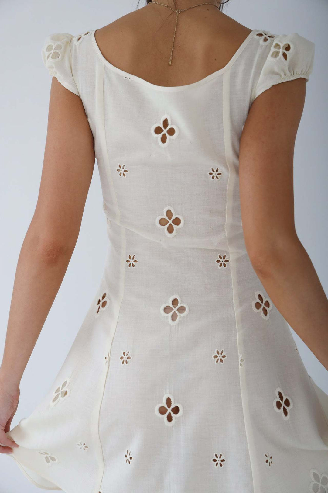 Close-up of the delicate fabric and elegant drape of a women's formal wedding guest midi dress.