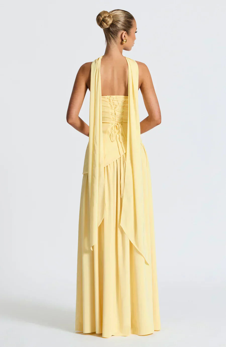 Flowing burgundy asymmetric maxi dress for women, ideal for a wedding, styled with high heels.