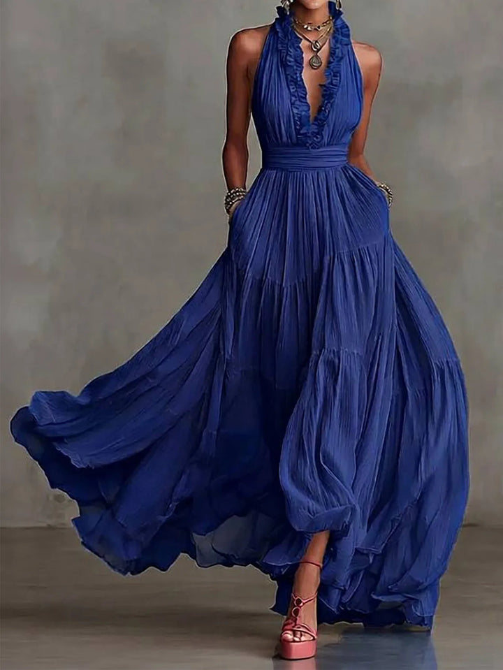 Chic women's backless maxi dress featuring a ruffle trim and plunging neckline. A stunning wedding guest or formal dress.