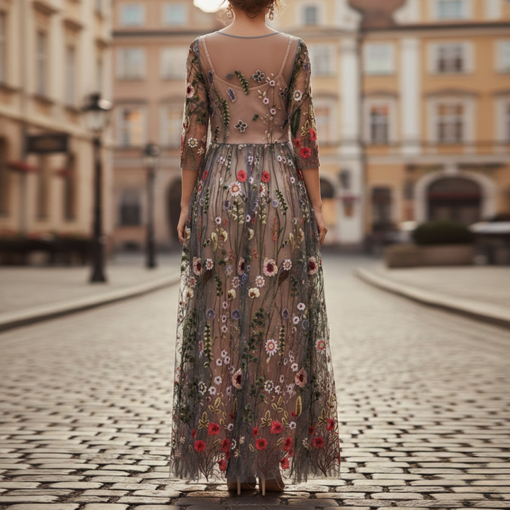 Stunning black embroidered maxi dress for women, featuring intricate floral patterns, three-quarter sleeves, and a flattering round neckline.