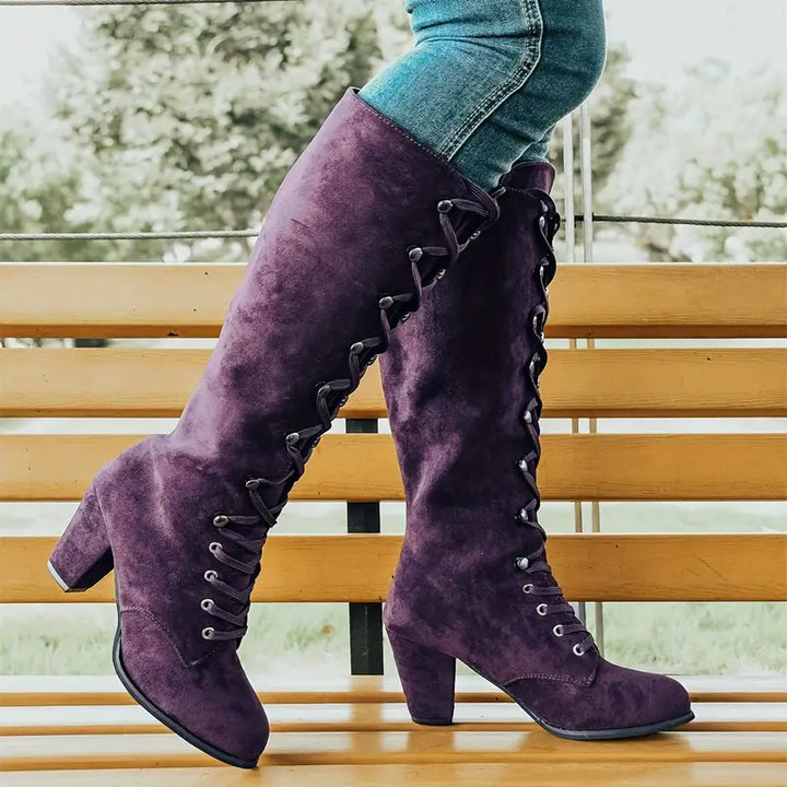 Stylish women's long boots with intricate lace-up detail and sturdy block heel for an elegant winter ensemble.