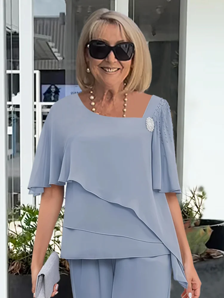 Formal women's two-piece outfit featuring an elegant cape top & straight leg trousers. Ideal for evening.