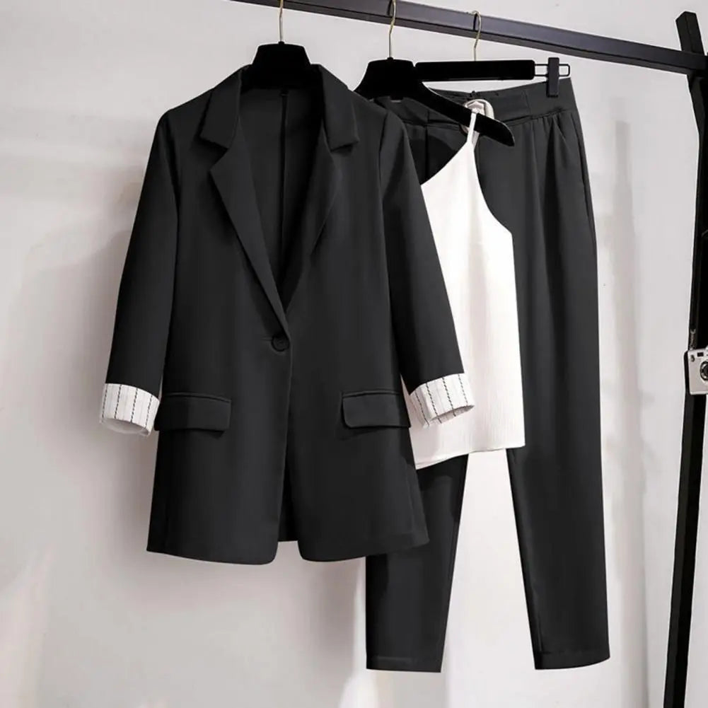 Elegant women's chic coordinated blazer, pants, and top suit set in a professional office setting.
