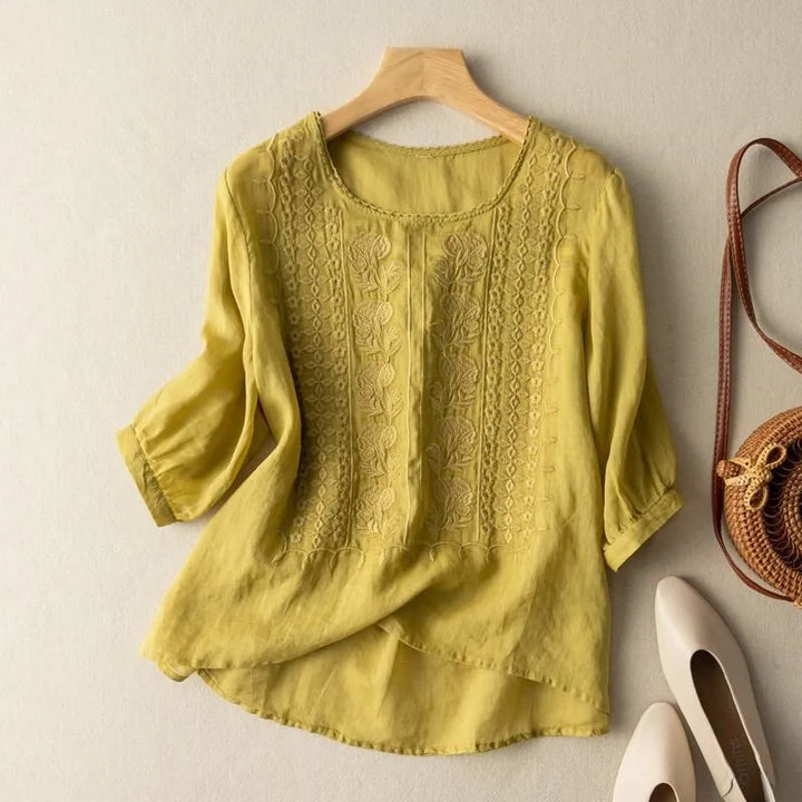 Women's round neck embroidered blouse with stylish puff sleeves & modern high-low hem; perfect for casual elegance.