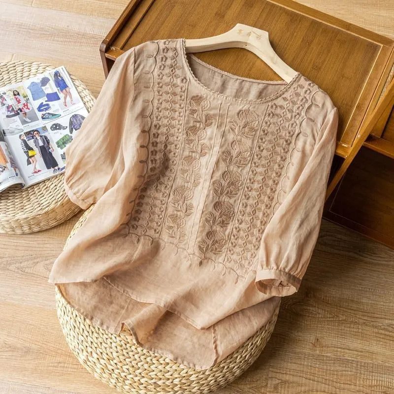 Fashionable women's embroidered puff sleeve blouse with a flattering high-low hem & round neck, ideal for spring fashion.