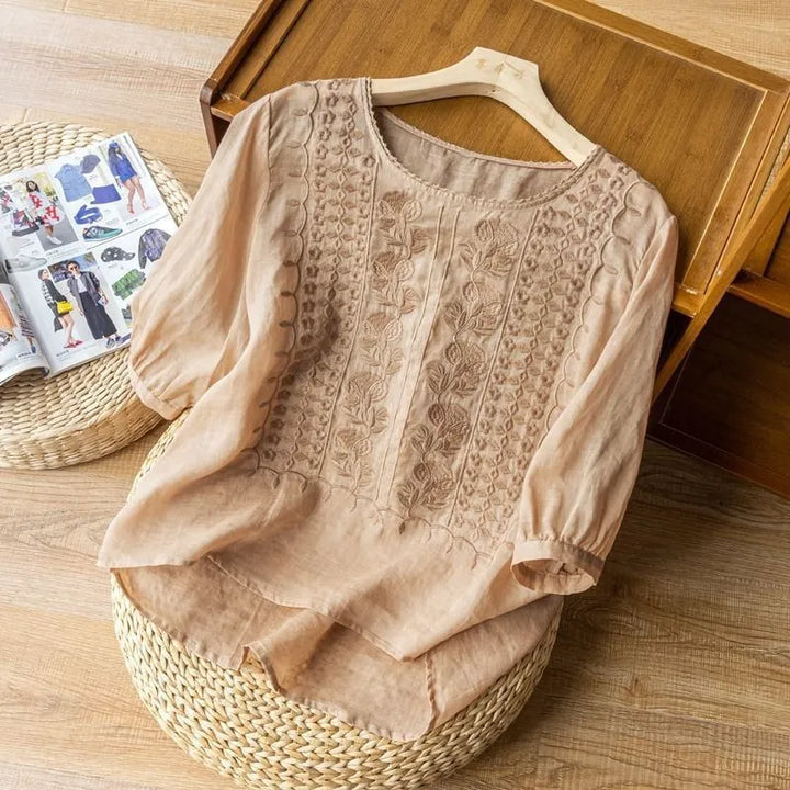 Fashionable women's embroidered puff sleeve blouse with a flattering high-low hem & round neck, ideal for spring fashion.