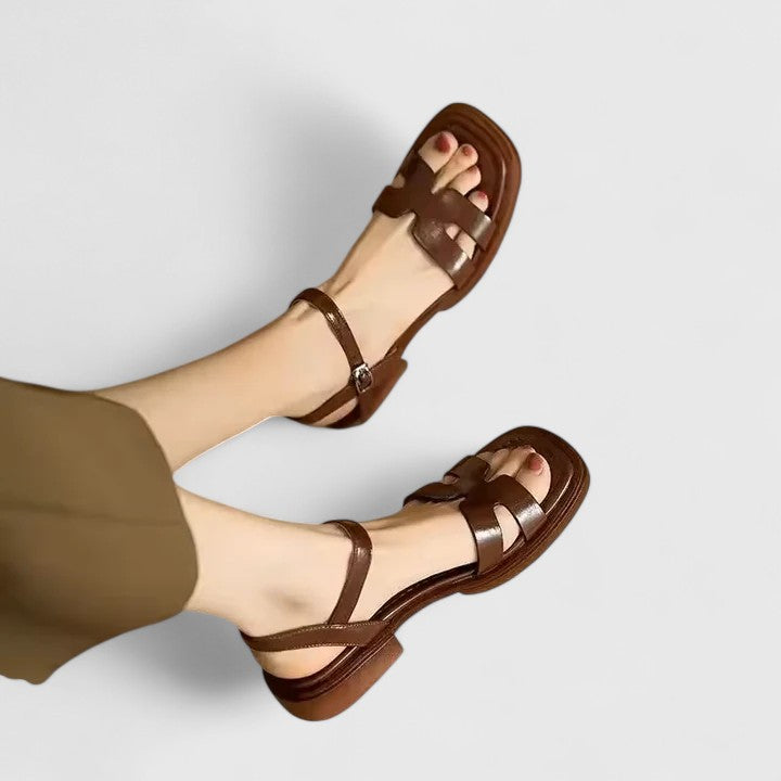Versatile women's flat sandals boasting a minimalist H-strap & cutout details with an ankle buckle closure.