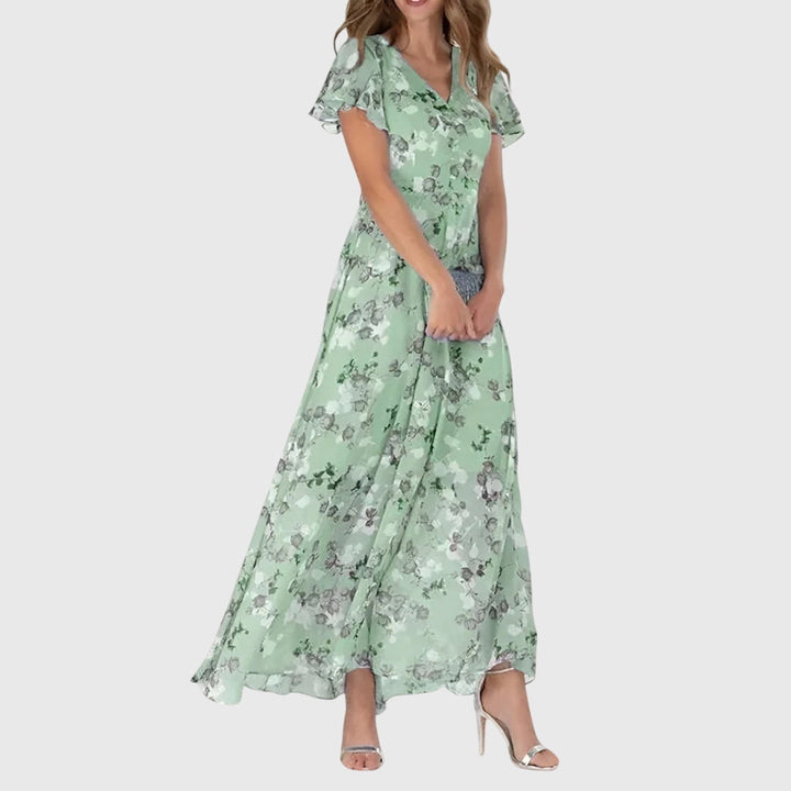 Stylish women's maxi dress with vibrant floral print, elegant V-neckline, and charming flutter sleeves for evening wear.