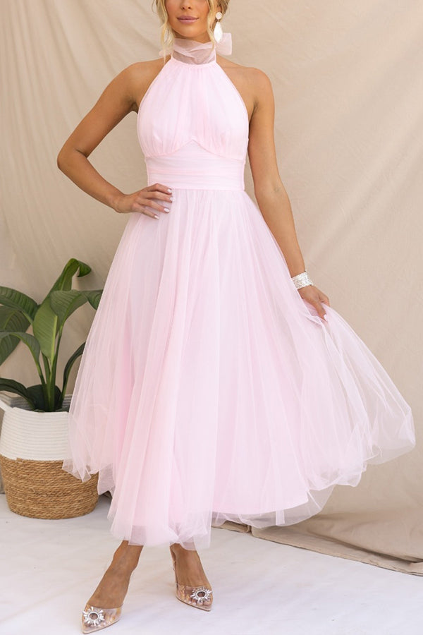 Luxurious flowy fabric of an elegant women's halter maxi dress. Perfect wedding guest or formal evening gown.