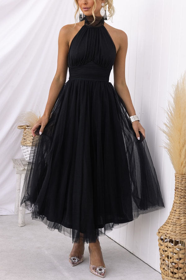Elegant woman gracefully posing in a flowy halter maxi wedding guest dress. Perfect special occasion evening gown.