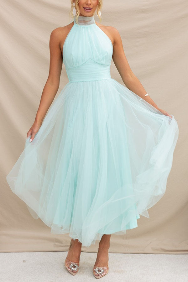 Woman walking elegantly in a flowy halter maxi formal dress. Ideal wedding guest or prom evening gown.