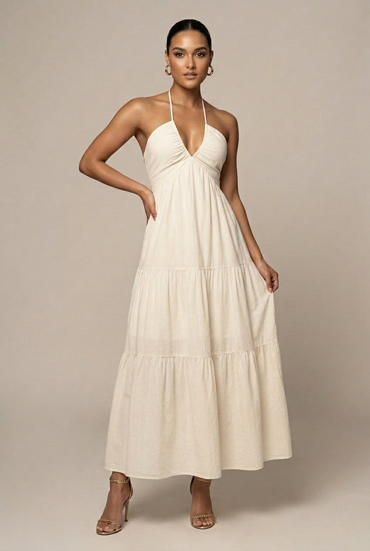 Elegant women's halter neck maxi dress with tiered ruffle skirt, open back, and tie waist, perfect for summer events.