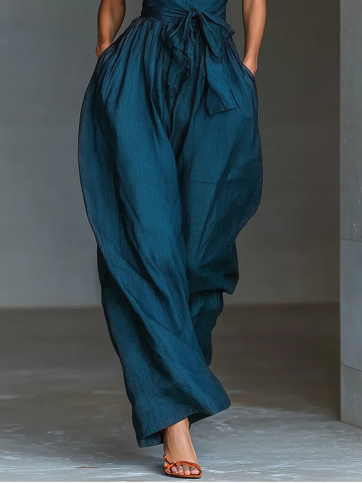 Chic women's navy halter jumpsuit with a flowing wide leg. A versatile and elegant option for vacation or formal wear.