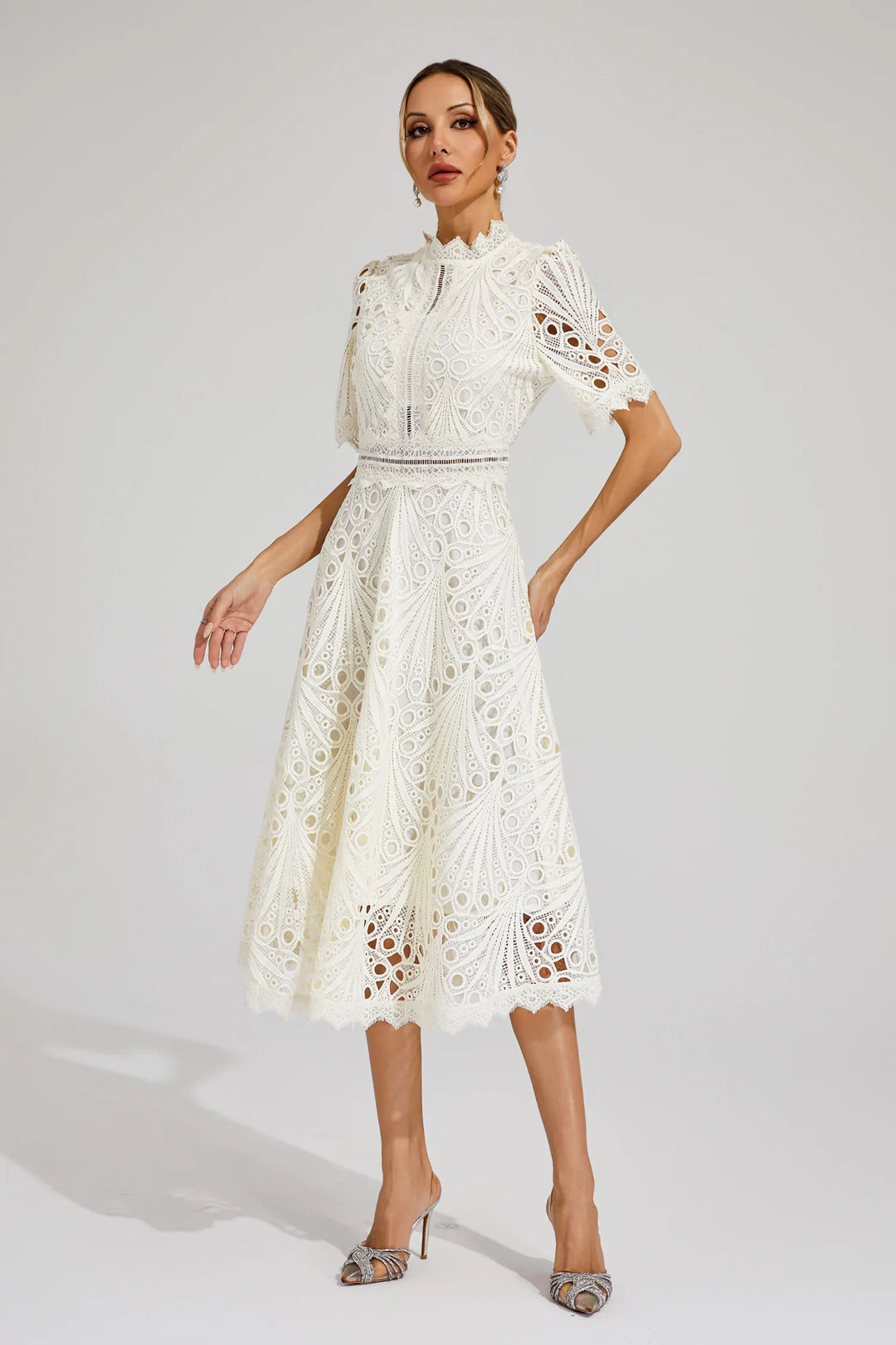 Stylish woman in a pink lace midi dress, exuding an air of elegance and confidence.