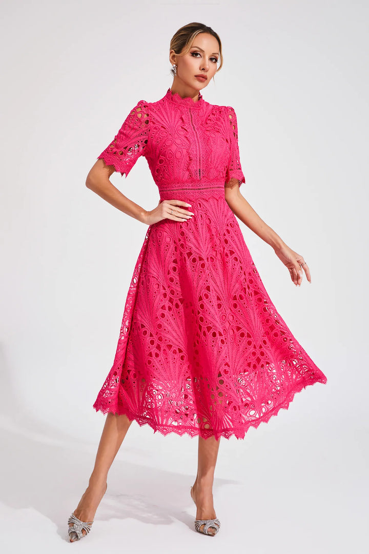 Full-length view of a woman wearing a stunning pink lace midi dress, a fashionable party dress.