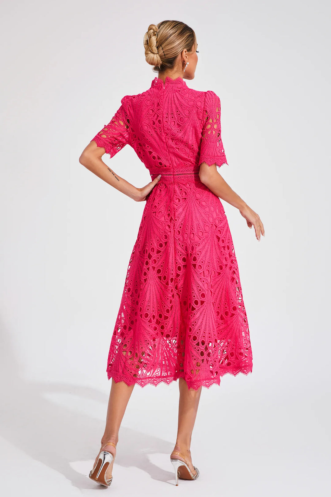 Detailed shot of the bodice and neckline of a white lace midi dress, sophisticated formal wear.