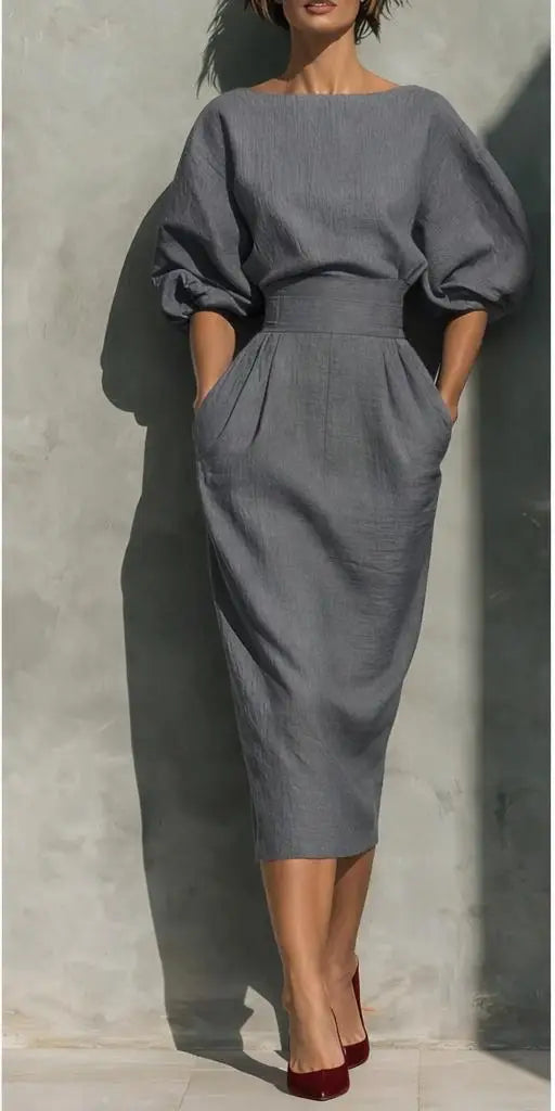 Woman wearing an elegant pleated midi dress with lantern sleeves, cinched waist, perfect for a sophisticated spring or summer event.