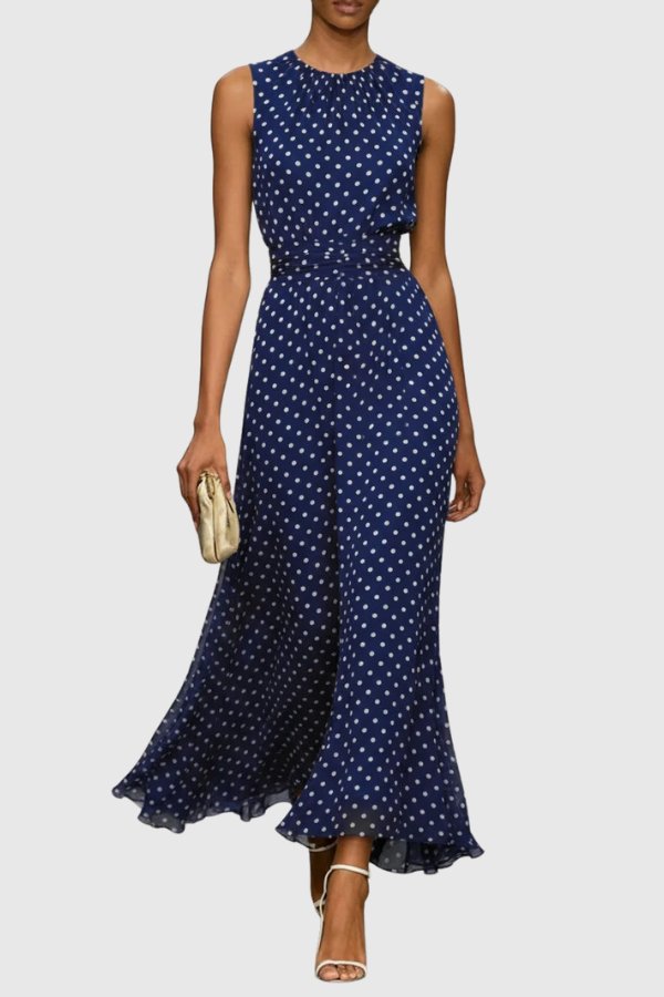Woman models elegant sleeveless polka dot maxi dress with ruffle hem, suitable for evening wear.