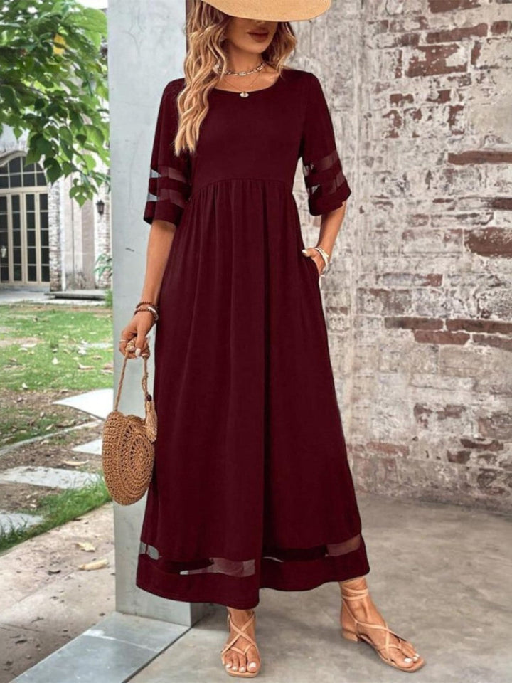 Black women's elegant round neck maxi dress. Flattering short sleeve design with a flowing skirt, perfect for evening wear.