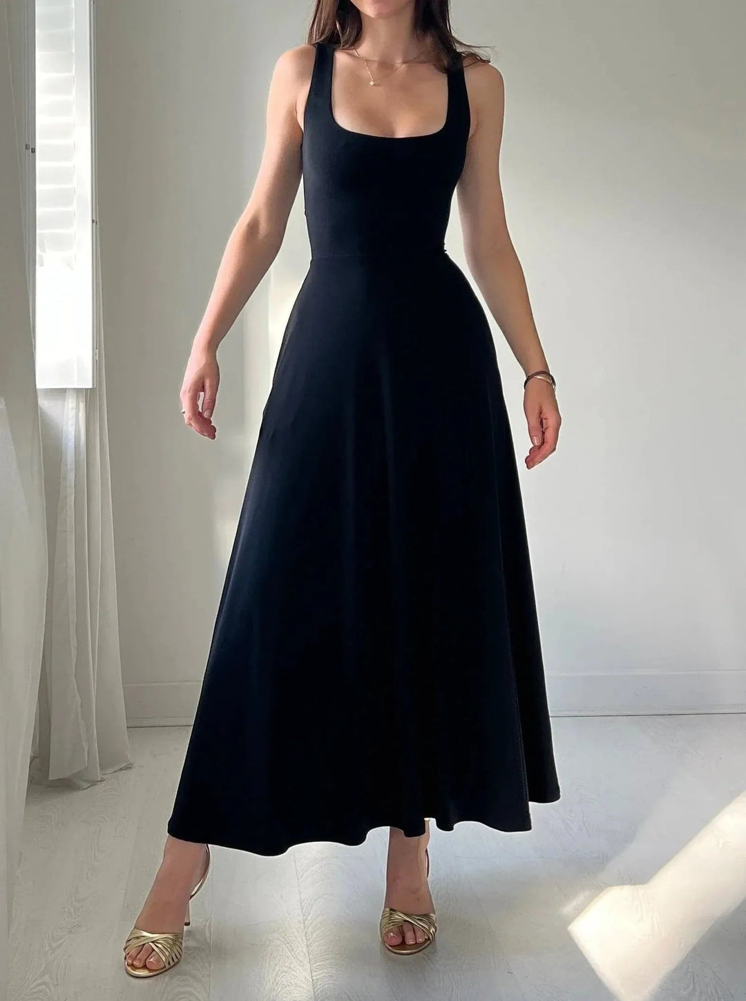 Elegant women's sleeveless A-line midi dress with square neck. Flattering fit for summer casual or evening wear.