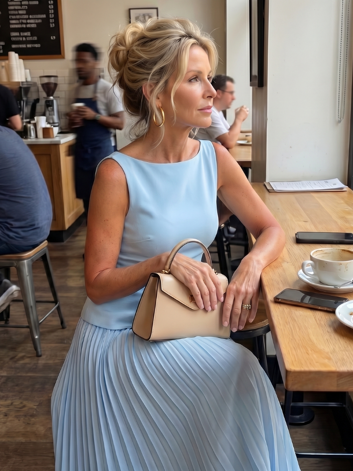 Chic women's coordinated set: structured sleeveless top & flowing pleated maxi skirt for events.