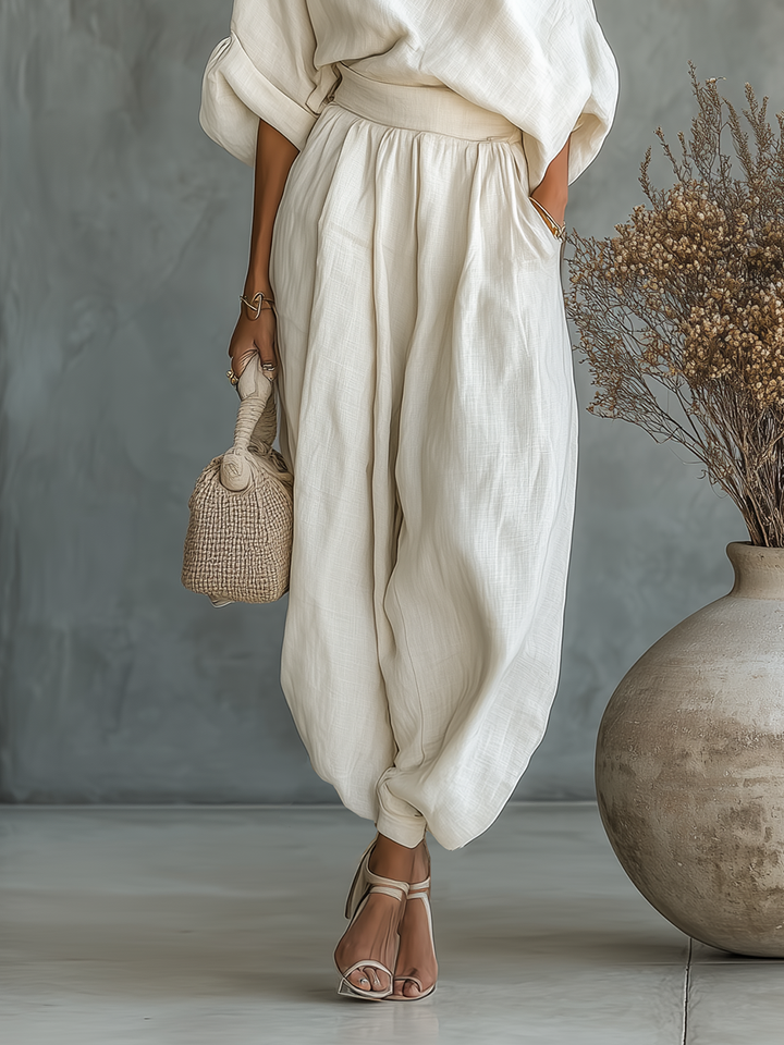 Modern women's two-piece set featuring an asymmetric drape top and flowy elastic waist wide-leg pants.