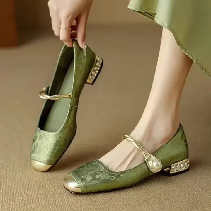 Side profile of women's elegant pearl flats, showcasing comfort design & metallic tip.