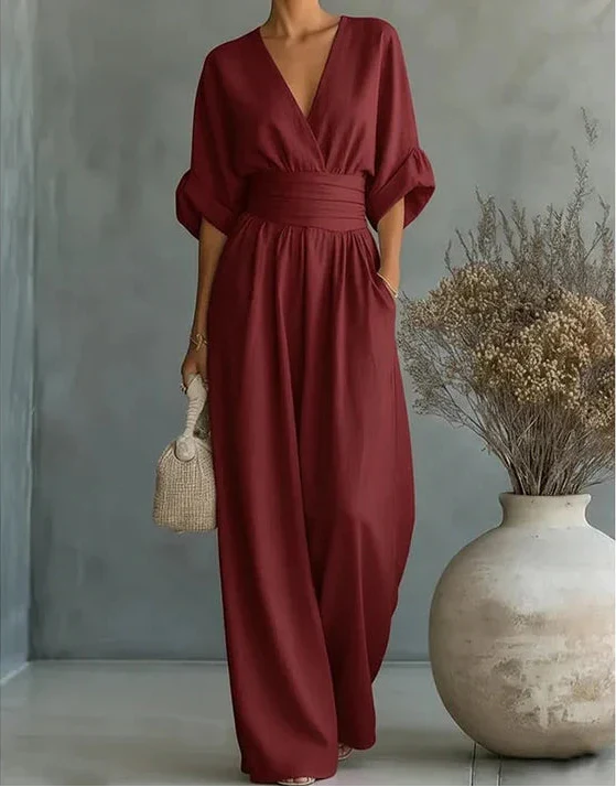 Flowing wide-leg women's jumpsuit with an elegant wrap front, perfect for comfortable occasion wear.