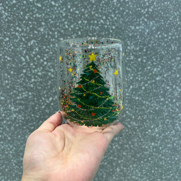 Christmas Tree Glass Tumbler, festive, with glitter, for holiday drinks. Ideal kitchen decor gift.
