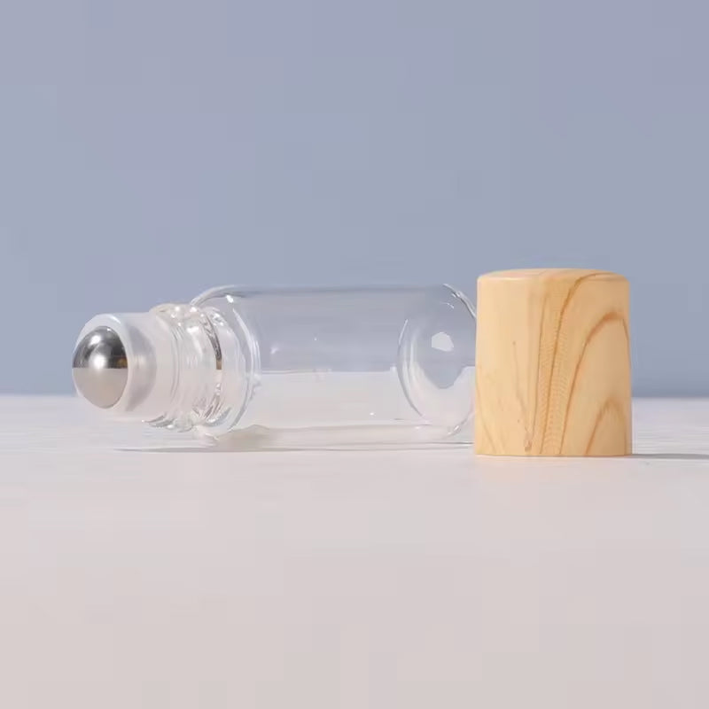 Top-down view of five refillable essential oil roller bottles with caps, showcasing their sleek and portable design