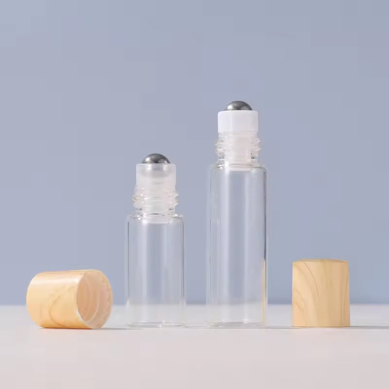 Hand holding a single essential oil roller bottle with a stainless steel ball, ready for aromatherapy application