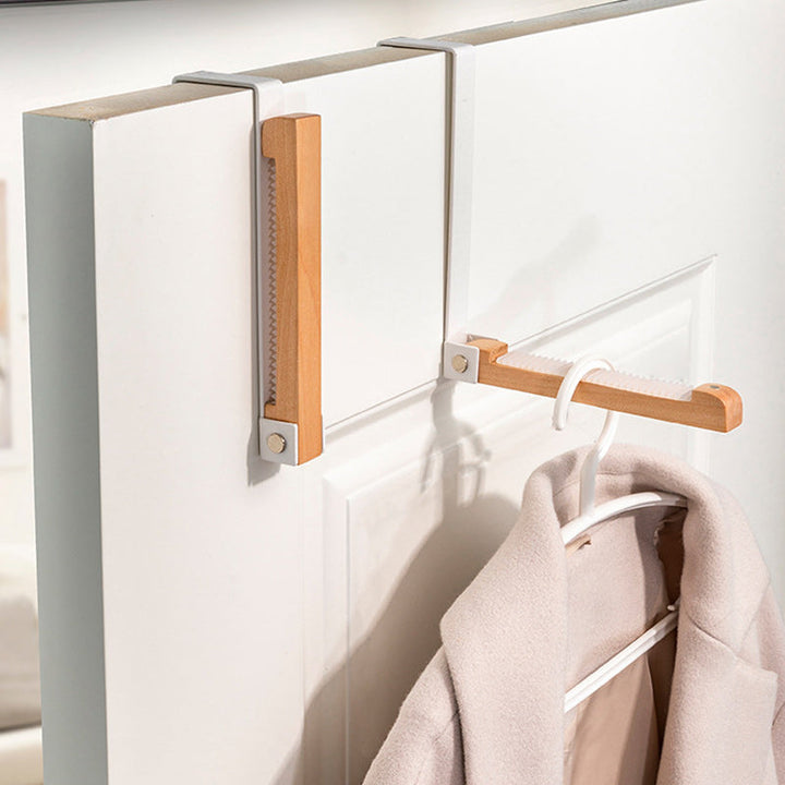 Foldable over-the-door hooks with natural wood and black metal, ideal for entryway organization.