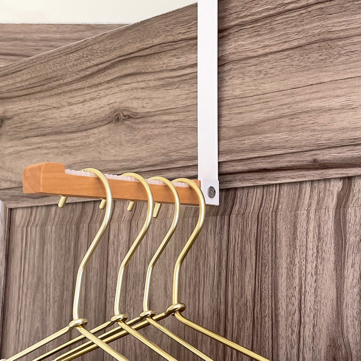Overhead shot of a foldable wood and metal door hook, emphasizing its sleek design.