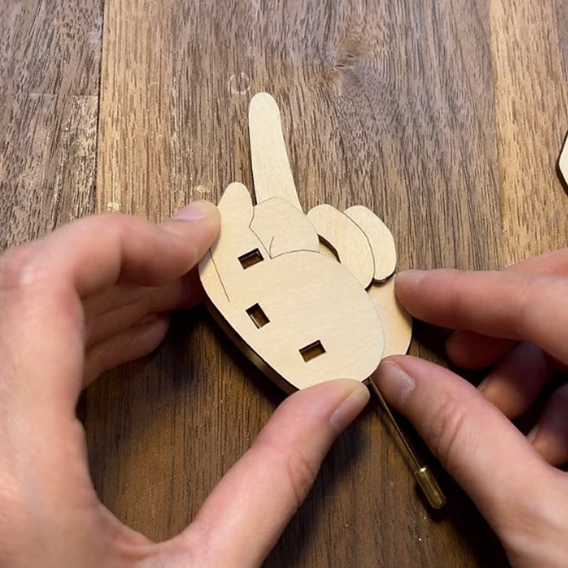Adult wearing a humorous wooden flippable finger brooch, showcasing this funny and unique accessory.