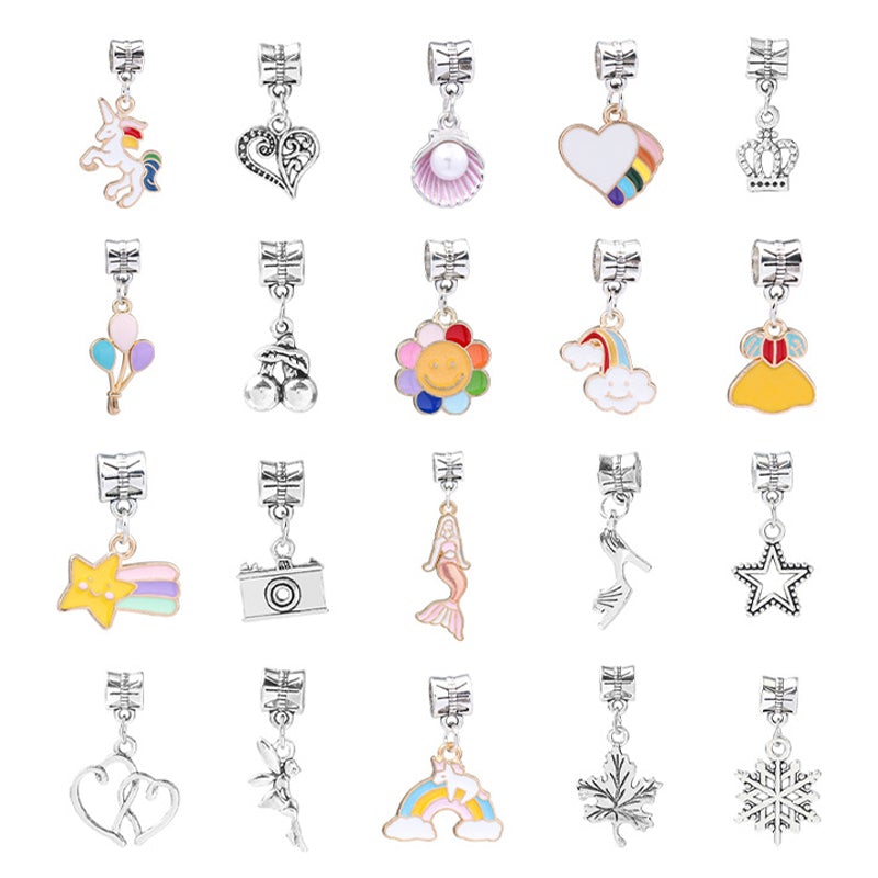 A close-up shot of a girl's hand selecting a pink heart charm from the DIY jewelry kit.