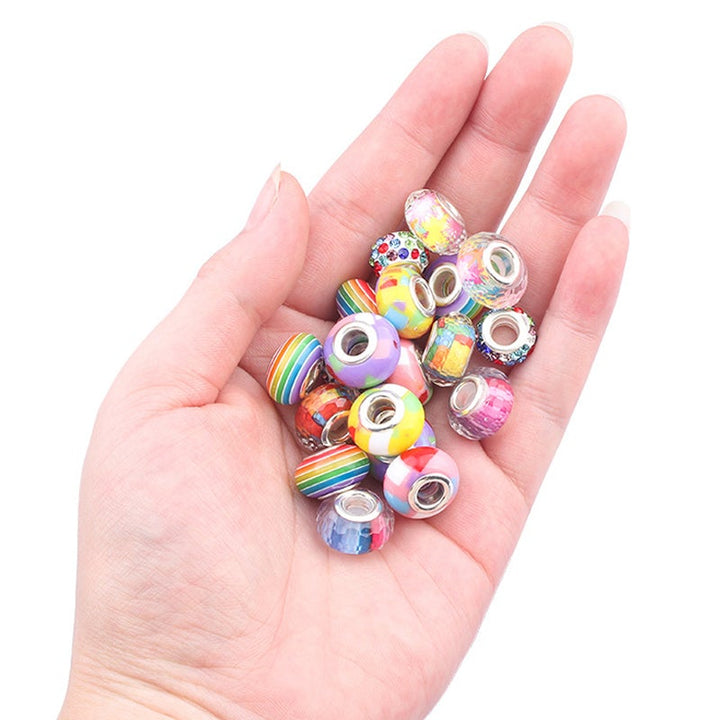 Girl's hands assembling a charm bracelet using beads from the DIY kit, focused on creative play.