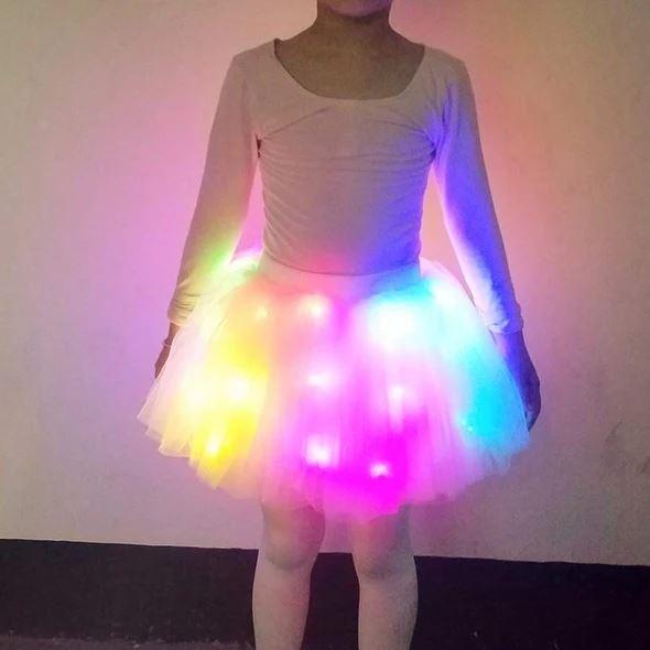 Girl smiling in a luminous LED tutu skirt, playful princess costume, fun party attire