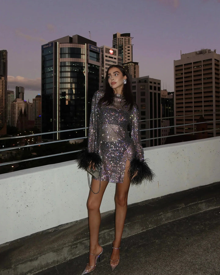 Trendy women's party dress: full sequin mini with luxurious feather sleeve cuffs. Ideal for night out.